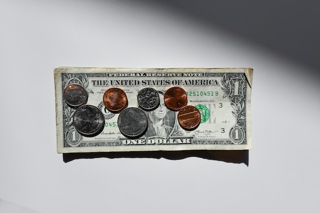an assortment of coins on top of a dollar bill